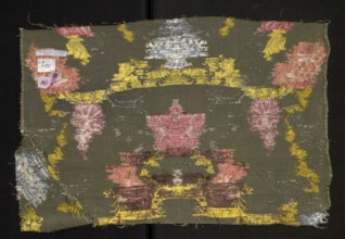 Fragment of fabric, silk, patterned with floral motifs. Pattern with a symmetrical composition of