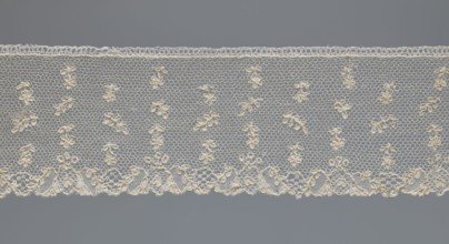Fragment of lace, one-sided strip of edge ornament made of plant forms with a motif of a pinnately