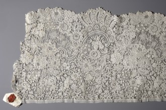 Fragment of Brussels lace; floral ornaments of densely placed roses, leaves, rocaille and