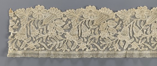 Lace fragment, bobbin lace with relief edges made with a needle on a tulle background, featuring a