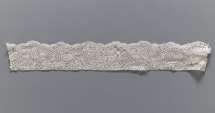 Lace fragment, bobbin lace, white, with a floral tendril ornament on a point de neige background,