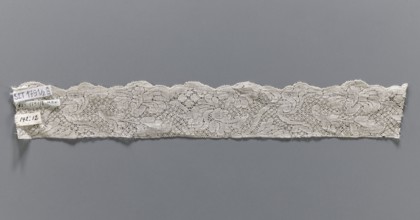 Lace fragment, bobbin lace, white, with a floral tendril ornament on a point de neige background,