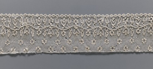 Lace fragment, needle Alençon lace; a flower branch parallel to the edge. Above the branch, in the