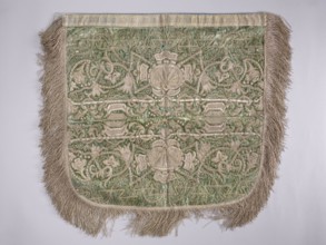 A hood from a church cope. The cope hood is made of pale green velvet. In the center, two