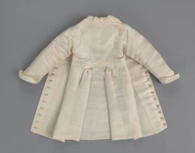 Children's dress made of cream satin. Long, fitted at the top, slightly flared at the bottom.