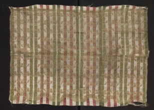 Fragment of silk fabric with fine stripes and a stylized plant ornament. Predominant colors: