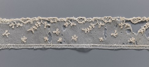 Fragment of needle lace of the point d'Alençon type. Cream needle lace with a mesh background of