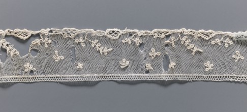 Fragment of needle lace of the point d'Alençon type. Cream, with a mesh background of twigs,
