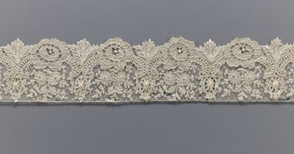 Lace fragment, purchase provenance noted; lace with plant ornaments. Serrated on one side, with a