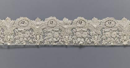 Lace fragment, lace with plant ornaments. Serrated on one side, with a pattern of flowers,