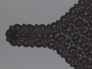 Cape, lace, in the form of a square with two wide, elongated lace ties. Continuous floral ornament