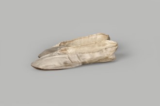 Flat women's slippers of white satin with top edge finished with ribbon. Flat-cut toes, symmetrical