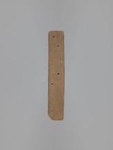 Double-sided gingerbread form. Obverse: female figure in a long patterned dress and a hat. Reverse: