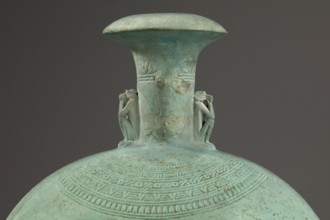 Flat round faience canteen with a narrow short neck ending in a chipped spout shaped like a papyrus