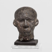 Head of a priest figurine, Male Egyptian sculptural fragment: a man's head, completely devoid of