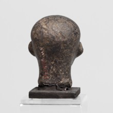Head of a priest figurine. A man's head fragment of a statuette, completely devoid of hair. Skull