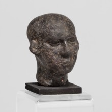 Head of a priest figurine, A man's head fragment of a statuette, completely devoid of hair.