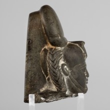 Fragment of a figurine of the god Khonsu — head with a lock of youth and a disc mounted on a