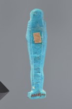 Ushabti, Mummy-shaped figurine standing on a base, back supported by a pillar/pilaster. Arms