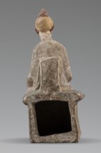 Figurine of a woman. A girl sitting in a chair is dressed in a soft white chiton over which a blue,