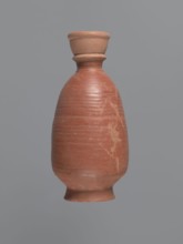 Bottle, unknown Aswan workshop; baggy-shaped bottle without preserved spout. The neck widens toward