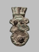 Amulet — single-sided tile with a schematic relief representation of Bes: a head with a feathered
