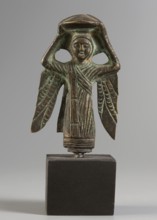 Figurine of a winged woman. Figurine depicting a woman standing frontally. Round face with clearly
