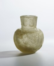 Bottle, glass with flattened bottom, rounded shoulders merging into a cylindrical neck decorated