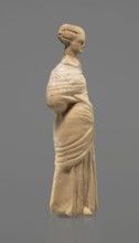 Terracotta figurine of a standing woman. Terracotta, molded figurine, Tanagra figurine. Figurine of