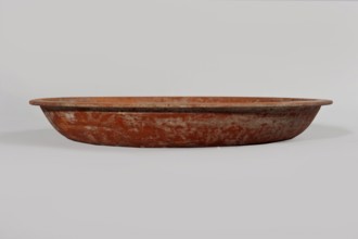 Terra sigillata plate. Plate with a flat bottom and almost vertical side walls. Narrow, flat rim.