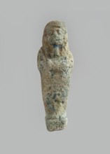 Ushabti. Carelessly made figurine with schematic facial features, in a narrow wig revealing the