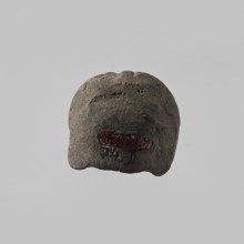Head of a female figurine, preserved from the chin up. High hairstyle with a wreath above the