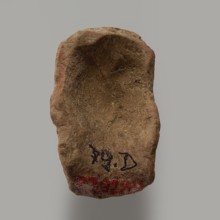 Fragment of a figurine - head of a man. Head of a male figurine. High forehead, above it fragments