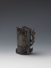 Vase on base, carved ornaments of flowers, birds, and stylized rocks; wooden oval base on three