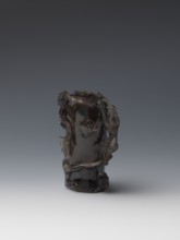Vase on base, carved ornaments; wooden base, oval on three legs. Carved decoration: stylized rocks,