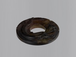 Disc with stylized antique-style decoration showing an entwining image of a lizard, stone almost