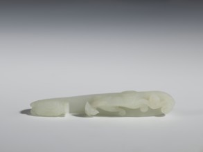 Belt clasp;, Milky-white, slightly translucent jadeite with slight colloid clusters. Carved and