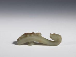 Belt clasp. Handle flattened on the sides, decorated with a lizard-dragon motif. Jadeite with