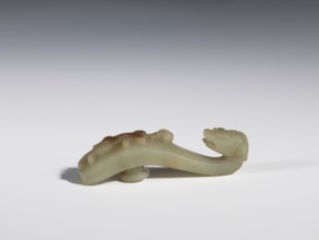 Belt clasp. Handle flattened on the sides, decorated with a lizard-dragon motif. Jadeite with