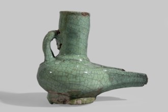 Jug-shaped oil lamp with a handle at the neck and a long burner, covered with a turquoise glaze on