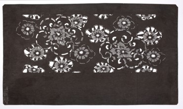 A katagami dyeing stencil cut into a pattern of stylized flower rosettes of various sizes
