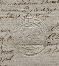 Round seal impression of the town of Nawogród. In a Baroque cartouche, a wall with a gate and three