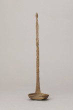 Shallow dipper with a quadrilateral handle narrowed at the top. The end of the handle is in the