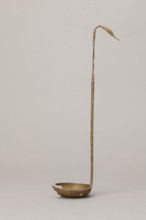 Shallow dipper with a quadrilateral handle, narrowed at the top. The end of the handle is in the