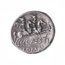 Denarius, obverse head of Roma in helmet at right; behind her a dog; in front of her a sign of