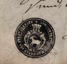 Round ink print of the seal of the town of Sleszyn. In a baroque cartouche, under an open crown