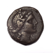 bronze coin, Pantikapaion; obverse: head of young Dionysus in ivy wreath facing right; reverse: bow