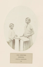 Praying boy and a girl with a book behind a desk from Chota Nagpur in eastern India, photograph,