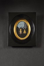 Décorations miniatures présentées sous cadre ovale