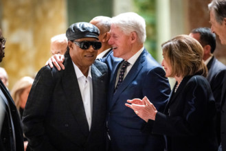 Musician Stevie Wonder (L) greets former US president Bill Clinton after Wonder sang at a memorial service for Ethel Ken